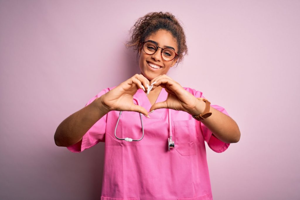 enfermeira fazendo o símbolo de coração com a mão em referência à qualidade da gestão de saúde pública