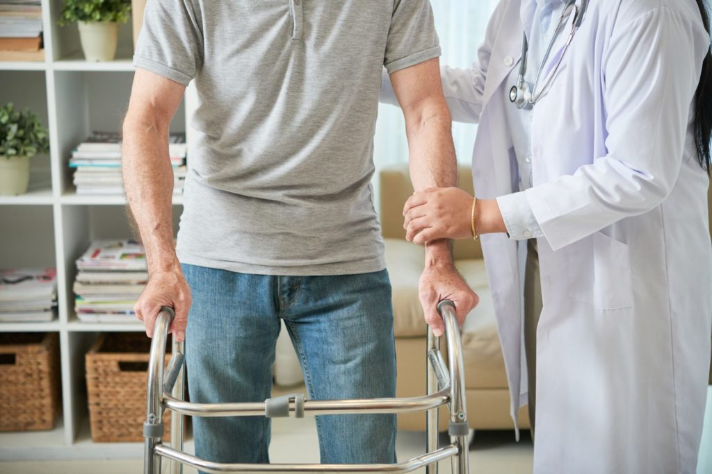 médica ajuda paciente a se mover com andador, revelando o impacto da gestão de custos hospitalares no resultados assistenciais