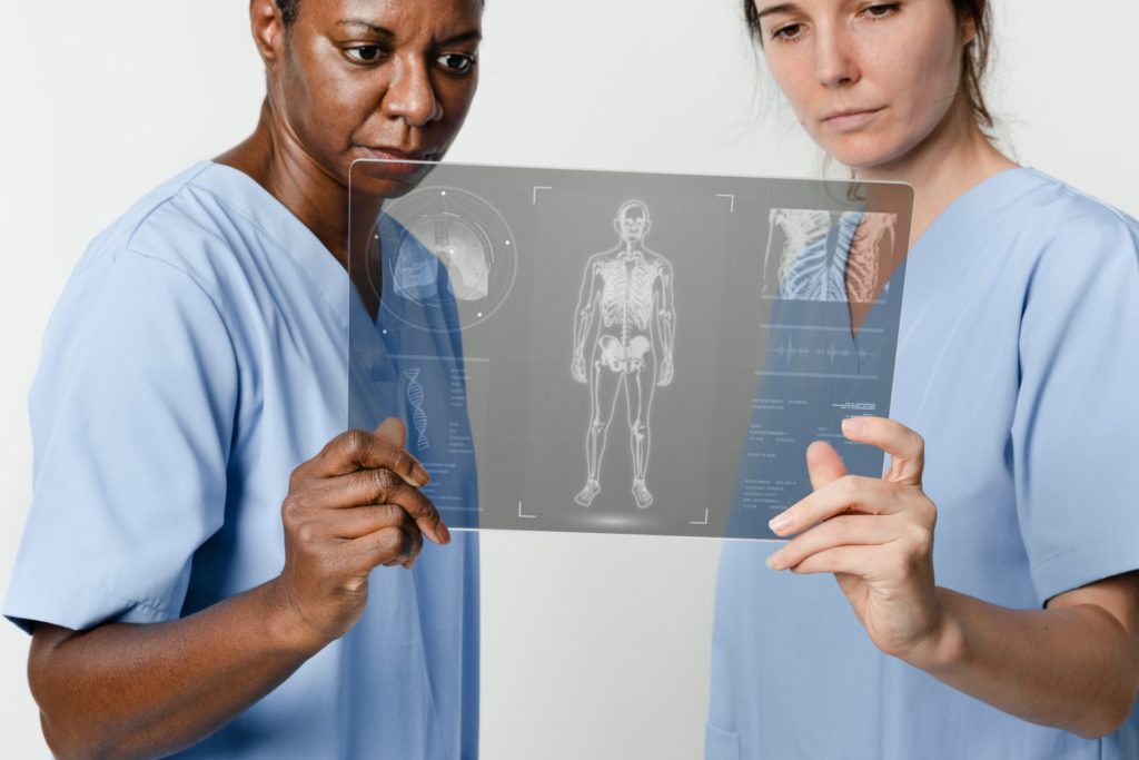médicos analisando a radiografia de um corpo humano com o auxílio da inteligência artificial na saúde